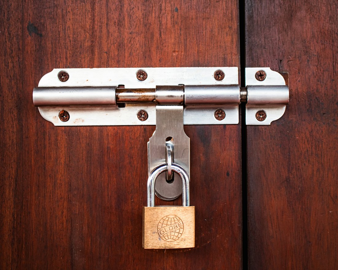 A padlock on a bolted door